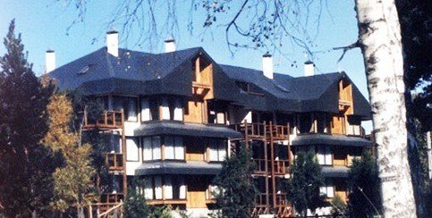 Torre residencial junto a marina con veleros.